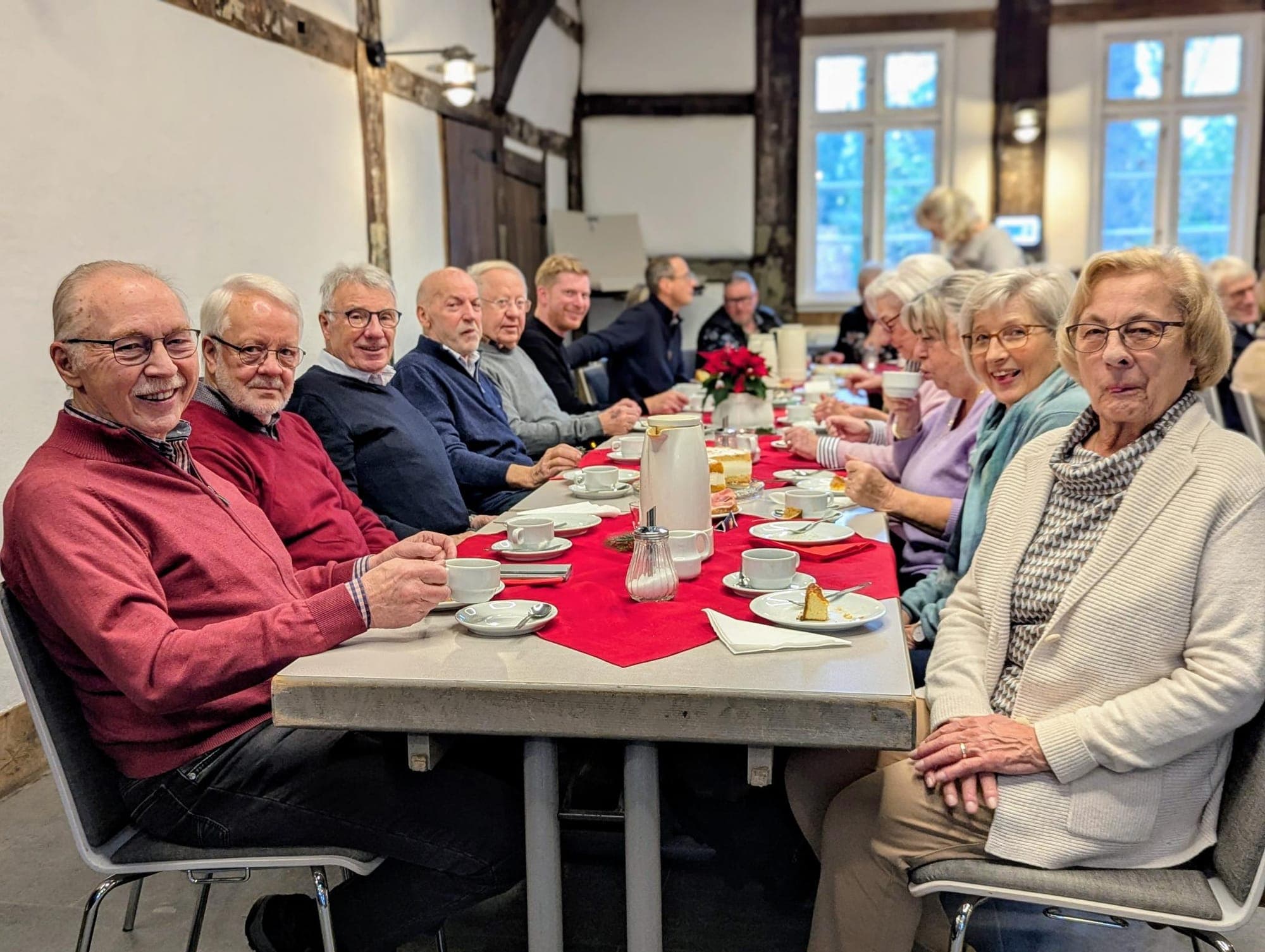 Adventskaffeetrinken — lange Kaffeetafel mit Mitgliedern im Bauernhaus