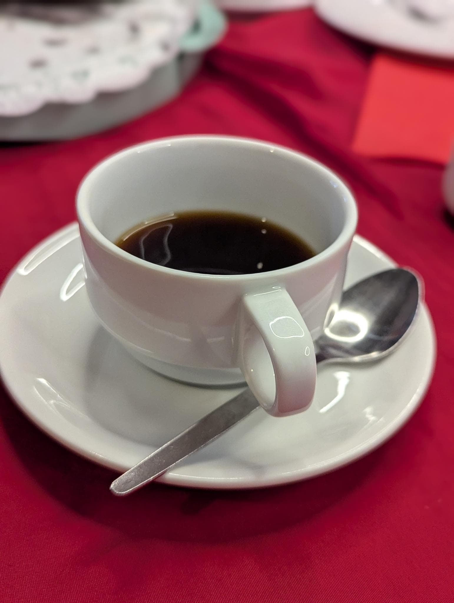 Tasse Kaffee auf rotem Tischtuch beim Adventskaffeetrinken