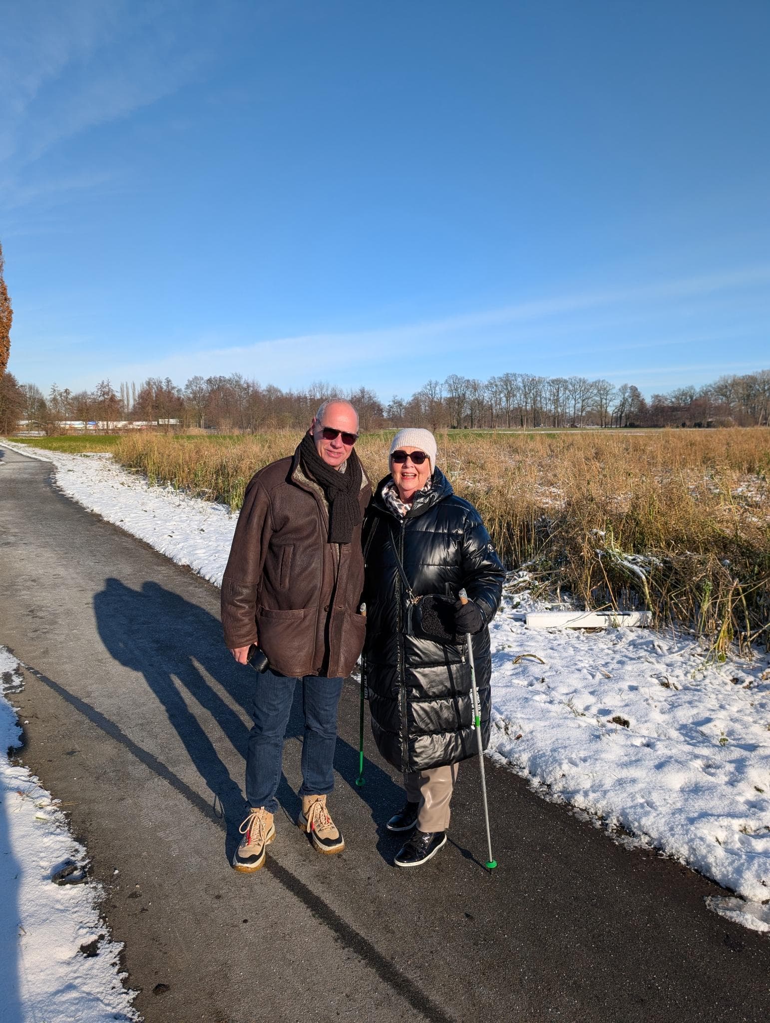 Zwei Wanderer Arm in Arm auf der winterlichen Strecke
